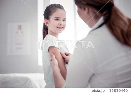Pleasant nice young woman putting a plaster 55830440
