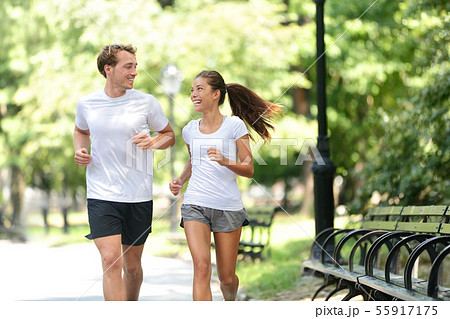 Friends couple happy running together in city park 55917175