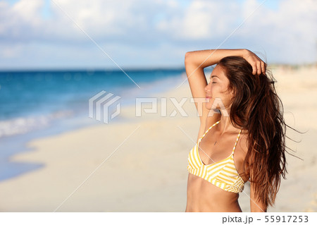 Carefree bikini woman enjoying sunset on beach Carefree bikini woman enjoying sunset on beach 55917253