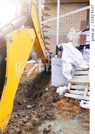 The excavator digging a trench near a cable house 55923437