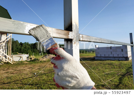 The worker paints the profile of a metal fence The worker paints the profile of a metal fence 55923497