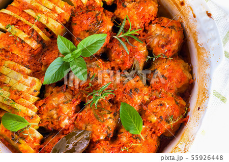 Homemade meatballs with tomato sauce in a white dish baked in the oven with herbs close up Homemade meatballs with tomato sauce in a white dish baked in the oven with herbs close up 55926448