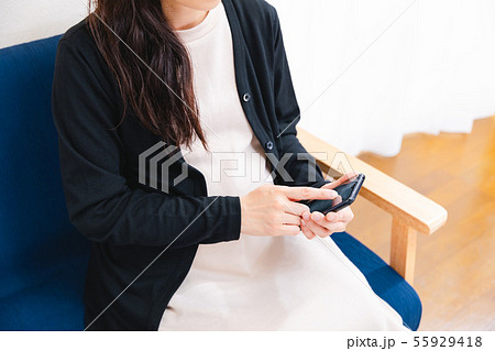 スマホをタップする妊婦 55929418