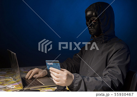 Anonymous hacker in mask programmer uses a laptop 55930467