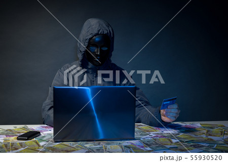 Anonymous hacker in mask programmer uses a laptop Anonymous hacker in mask programmer uses a laptop 55930520