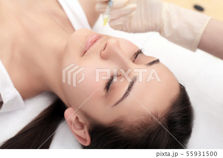 Beautiful young girl of European appearance on the procedure of injecting injections in the salon of 55931500