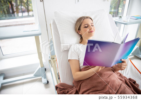 Beautiful young woman reading in hospital room 55934368