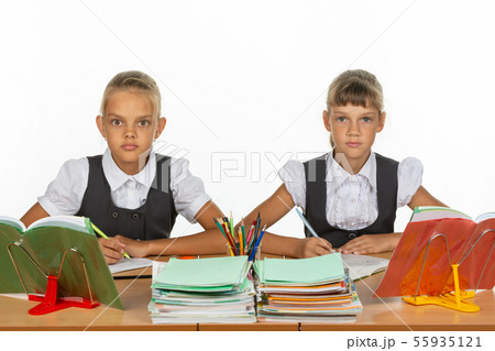 Two schoolgirls gaze intently and emotionlessly Two schoolgirls gaze intently and emotionlessly 55935121