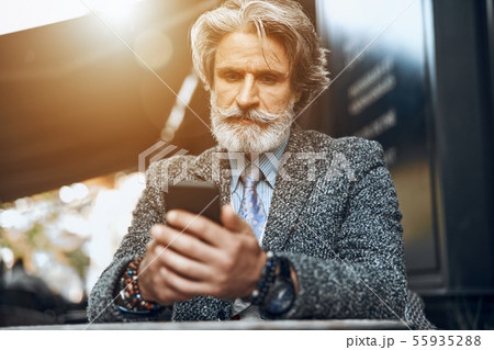 Mature man concentrated on smartphone stock photo 55935288