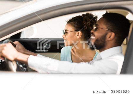 Young black couple in car on road trip, travelling together Young black couple in car on road trip, travelling together 55935620
