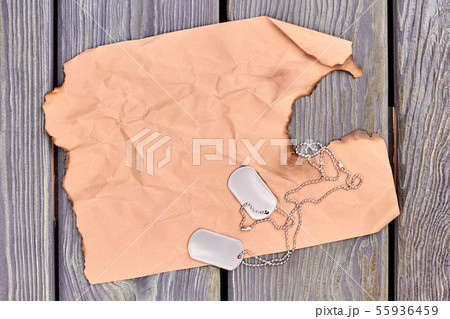 Burnt old paper and dog tags. 55936459