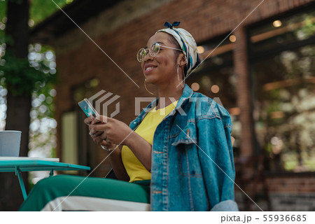 Young african american female holding mobile phone Young african american female holding mobile phone 55936685