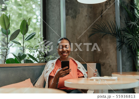 Young african american woman using smartphone in cafe Young african american woman using smartphone in cafe 55936813
