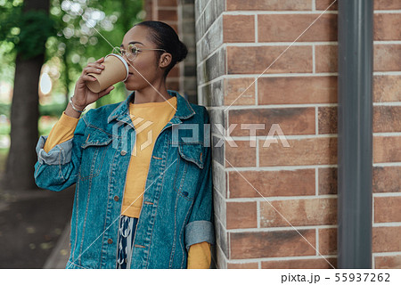 Young african american woman drinking coffee in city Young african american woman drinking coffee in city 55937262