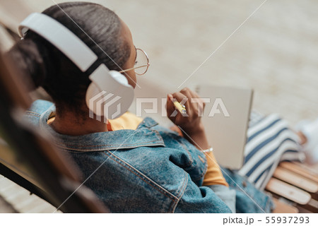 Young african american woman writing notes in notepad Young african american woman writing notes in notepad 55937293