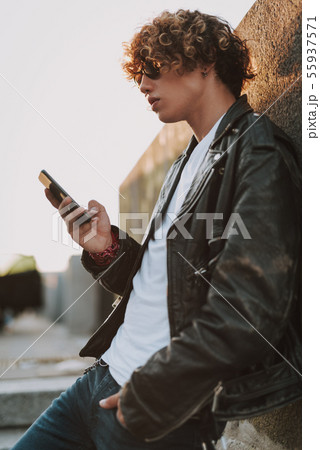 Young man near the wall with smartphone 55937571