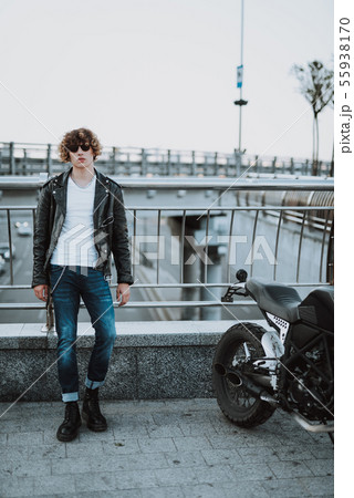 Young biker on the bridge with motorbike near 55938170