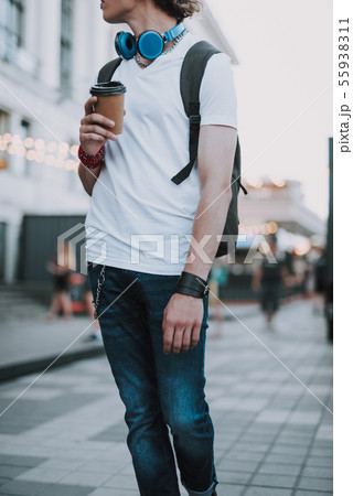 Man in jeans standing with coffee to go Man in jeans standing with coffee to go 55938311