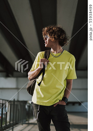 Young curly man standing with one hand in pocket 55938499