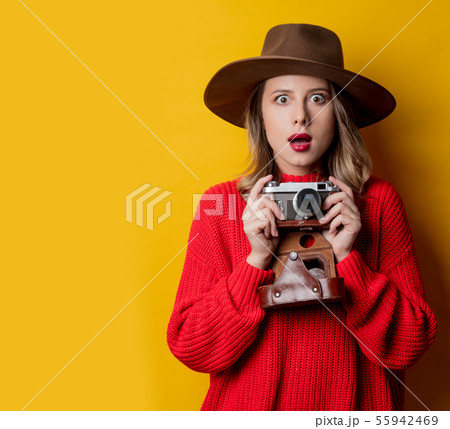 Woman in hat with vintage camera 55942469