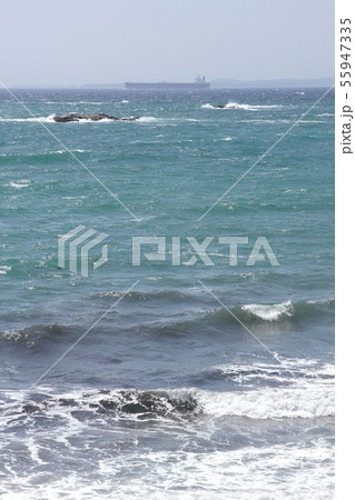 千葉県の内房 鋸南町の元名海水浴場から東京湾を航行する貨物船と遠く三浦半島方面を見るの写真素材