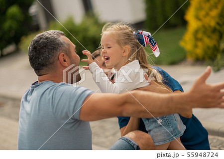 Cute blonde girl making funny face while hugging parents 55948724