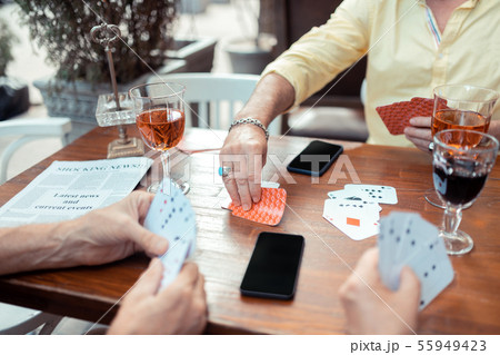 Man taking cards while gambling with old friends 55949423