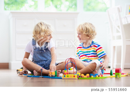 Kids play wooden railway. Child with toy train. Kids play wooden railway. Child with toy train. 55951660