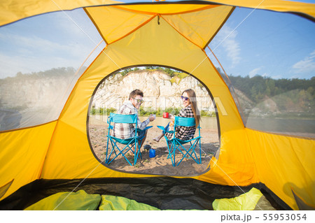 People, tourism and nature concept - Cute couple sitting with a cat near yellow tent People, tourism and nature concept - Cute couple sitting with a cat near yellow tent 55953054