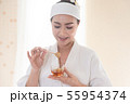 women holding cup of honey on hand during the spa 55954374