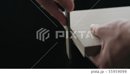 woodworker hand sanding walnut board with file woodworker hand sanding walnut board with file 55959099