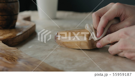 woodworker applying oil finish to olive wood scoop 55959187