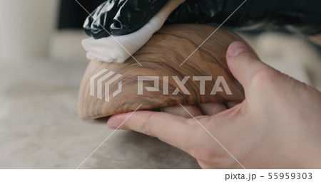 woodworker applying oil finish to olive wood bowl 55959303