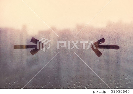 Foggy glass on blue yellow window with drawn two arrows opposite each other, concept photo, copy Foggy glass on blue yellow window with drawn two arrows opposite each other, concept photo, copy 55959646