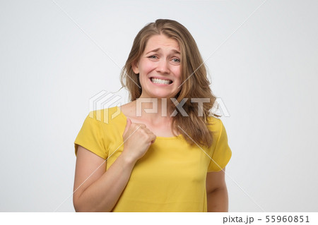 Woman feeling awkward, looking with weird smile after making mistake and being guilty 55960851