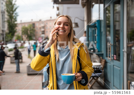 Enchanting blonde young woman with smartphone while on the street 55961563