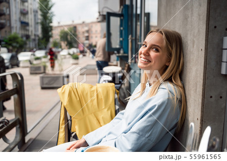 Close up portrait of a young woman sitting at the table in a street cafe 55961565