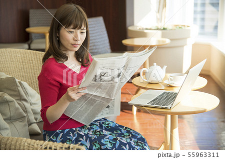 新聞を読む女性　カフェ　ラウンジ 55963311