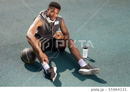 Handsome African Sportsman Using Smartphone Outdoors Handsome African Sportsman Using Smartphone Outdoors 55964131