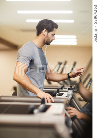 Man Running on Treadmill in Gym Man Running on Treadmill in Gym 55964263