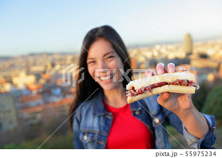 Jamon Iberico Sandwich - woman eating in Barcelona 55975234