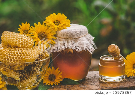 Honey jar and wooden stick on table. Ukrainian Honey jar and wooden stick on table. Ukrainian 55978867