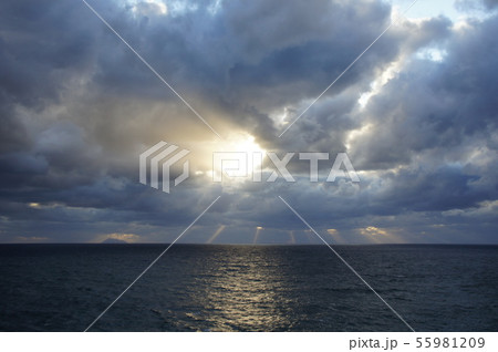 暗い海と雲の切れ間の陽射し 55981209