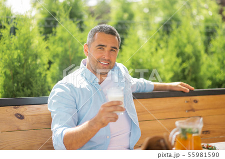 Handsome man smiling while having early meal outside Handsome man smiling while having early meal outside 55981590