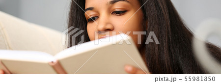 Smiling black woman read story book at home 55981850