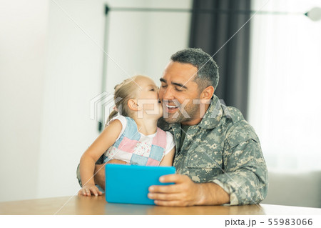 Lovely girl kissing daddy wearing military uniform 55983066