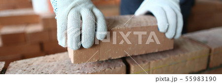 Male hands putting brick 55983190