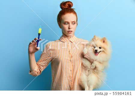 girl being shocked after bad reaction of dog on the injection 55984161