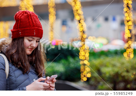 beautiful young girl holding smart phone on a beautiful young girl holding smart phone on a 55985249