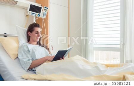 Woman in hospital bed reading the bible 55985521